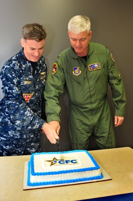 MISAWA AIR BASE, Japan – U.S. Navy Capt. Christopher A. Rodeman, Naval Air Facility Misawa commander, and U.S. Air Force Col. Al Wimmer, 35th Fighter Wing vice commander, cut a cake celebrating the 50th Anniversary of the Combined Federal Campaign here, Oct. 3. The CFC is a charitable fundraising campaign run by federal volunteers and is the largest employee campaign in the world. (U.S. Air Force photo/Staff Sgt. Nathan Lipscomb)