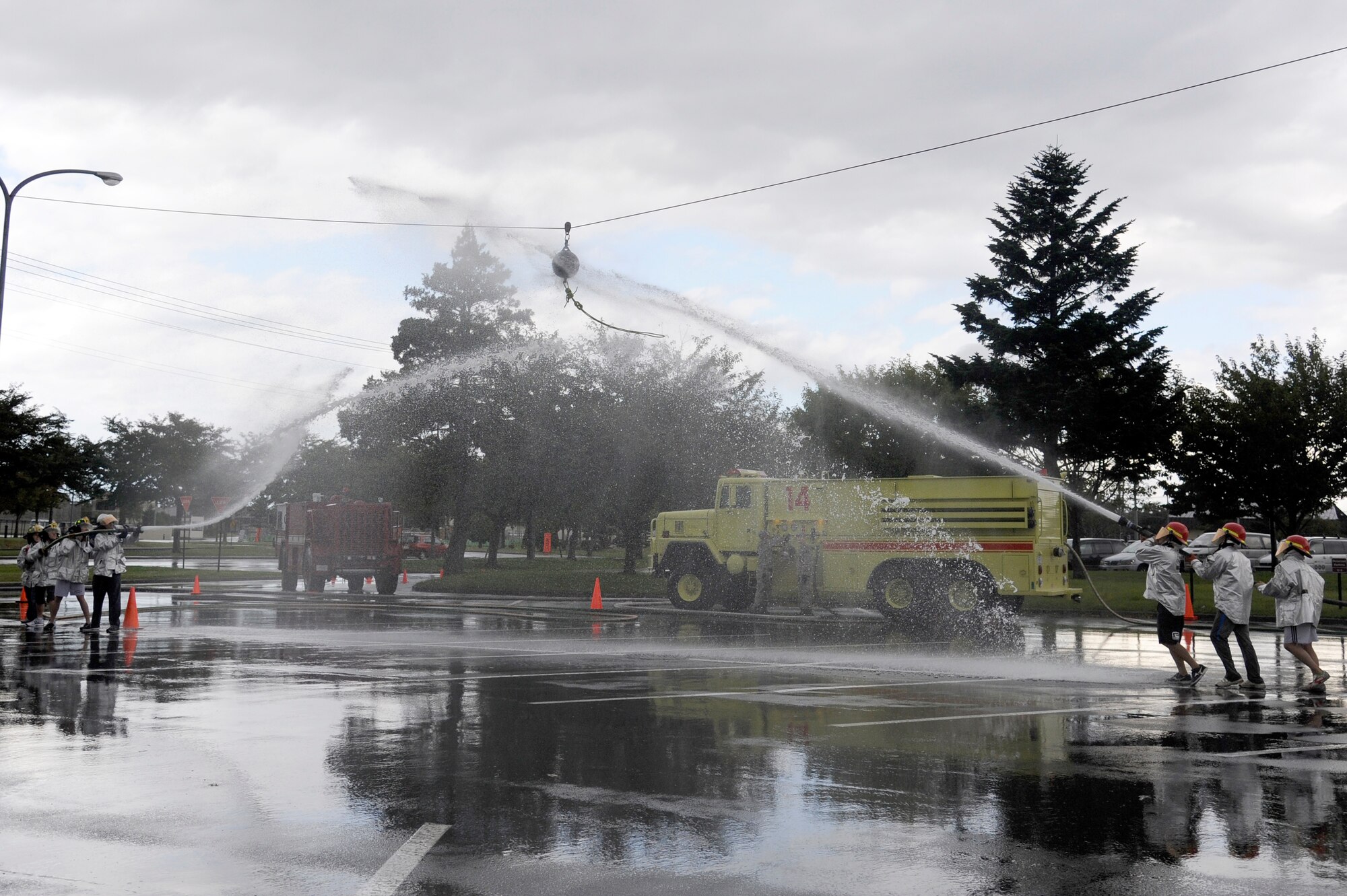 MISAWA AIR BASE, Japan - Firefighters from the 35th Civil Engineer Squadron compete against firefighters from Towada City during the water ball event part of the fire muster competition held at the base exchange parking lot here Oct. 2.  Firefighters from the 35 CES along with firefighters from Misawa City and Towada City participated in a fire muster to kick off Fire Prevention Week. Fire Prevention Week was established to commemorate the Great Chicago Fire, the tragic 1871 blaze that killed more than 250 people, left 100,000 homeless, destroyed more than 17,400 structures and burned more than 2,000 acres. In 1920, President Woodrow Wilson issued the first National Fire Prevention Day proclamation, and since 1922, Fire Prevention Week has been observed on the Sunday through Saturday period in which October 9 falls. (U.S. Air Force photo/Tech. Sgt. Marie Brown)
