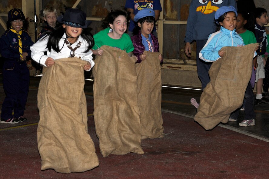 American and Japanese Boy and Girl Scouts participate in a sack race during International Scout Day at a Hangar, Misawa Air Base, Japan, Oct. 1. International Scout Day is a local celebration of bilateral friendships and cooperation. Japanese and U.S. Scouts have annually gathered at Misawa Air Base since 1959, but the first official International Scout Day occurred in 1992. More than 200 Boy and Girl Scouts from Misawa Air Base and more than 300 Japanese Boy and Girl Scouts attended this year’s event. (U.S. Air Force photo/Tech. Sgt. Marie Brown) 
