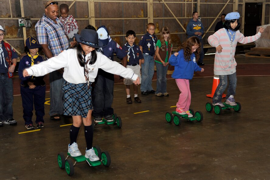 American and Japanese Boy and Girl Scouts attempt to move across the floor on a pedal scooter during International Scout Day at a Hangar, Misawa Air Base, Japan, Oct. 1. International Scout Day is a local celebration of bilateral friendships and cooperation. Japanese and U.S. Scouts have annually gathered at Misawa Air Base since 1959, but the first official International Scout Day occurred in 1992. More than 200 Boy and Girl Scouts from Misawa Air Base and more than 300 Japanese Boy and Girl Scouts attended this year’s event. (U.S. Air Force photo/Tech. Sgt. Marie Brown) 
