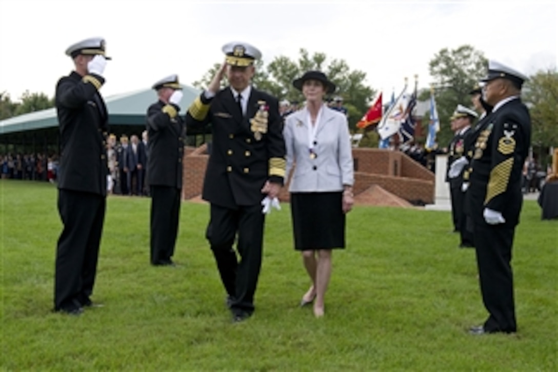 The 17th Chairman of the Joint Chiefs of Staff, U.S. Navy Adm. Mike Mullen and his wife Deborah go through the side boys as they are piped ashore at the chairman of the Joint Chiefs of Staff change of responsibility ceremony on Summerall Field, Joint Base Myer-Henderson Hall, Va., on Sept. 30, 2011.  Mullen is retiring after 43 years of service as U.S. Army Gen. Martin Dempsey takes over as chairman.  