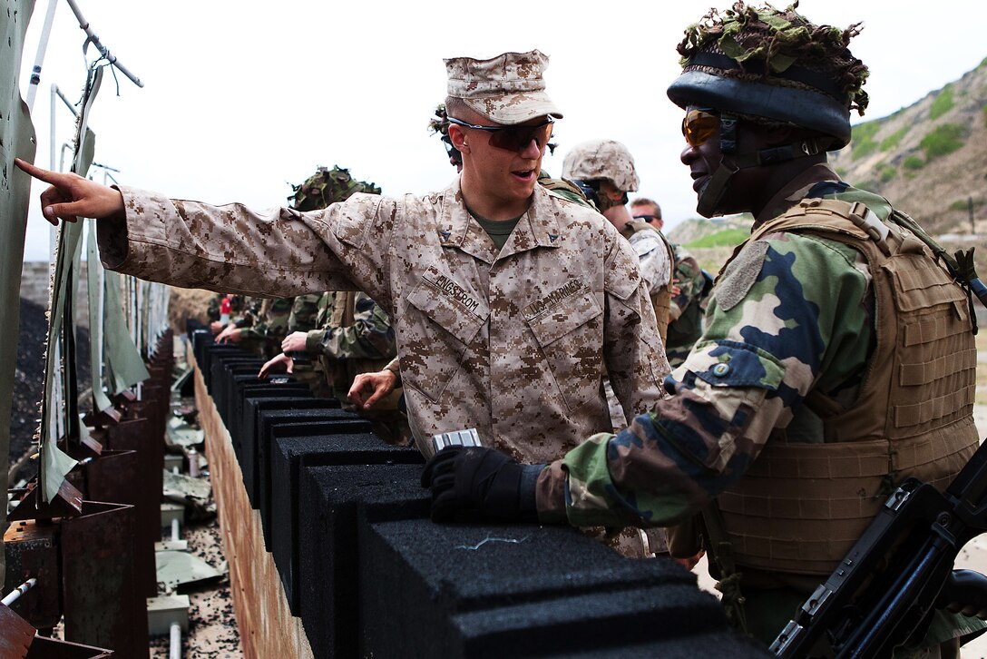 Lance Cpl. Derek L. Engstrom, a rifleman with Company G, 2nd Battalion, 3rd Marine Regiment, compliments Chief-Corporal Christel Namseney, a rifleman with 8th Infantry Regiment, Company de Clerage et D’Appius, on his shooting during the combat marksmanship program training here Oct. 4 during Exercise AMERCAL 2011. The purpose of the exercise is to enhance interoperability, improve military-to-military relations and sharpen warfighting skills through a combined training exchange with the NATO ally.