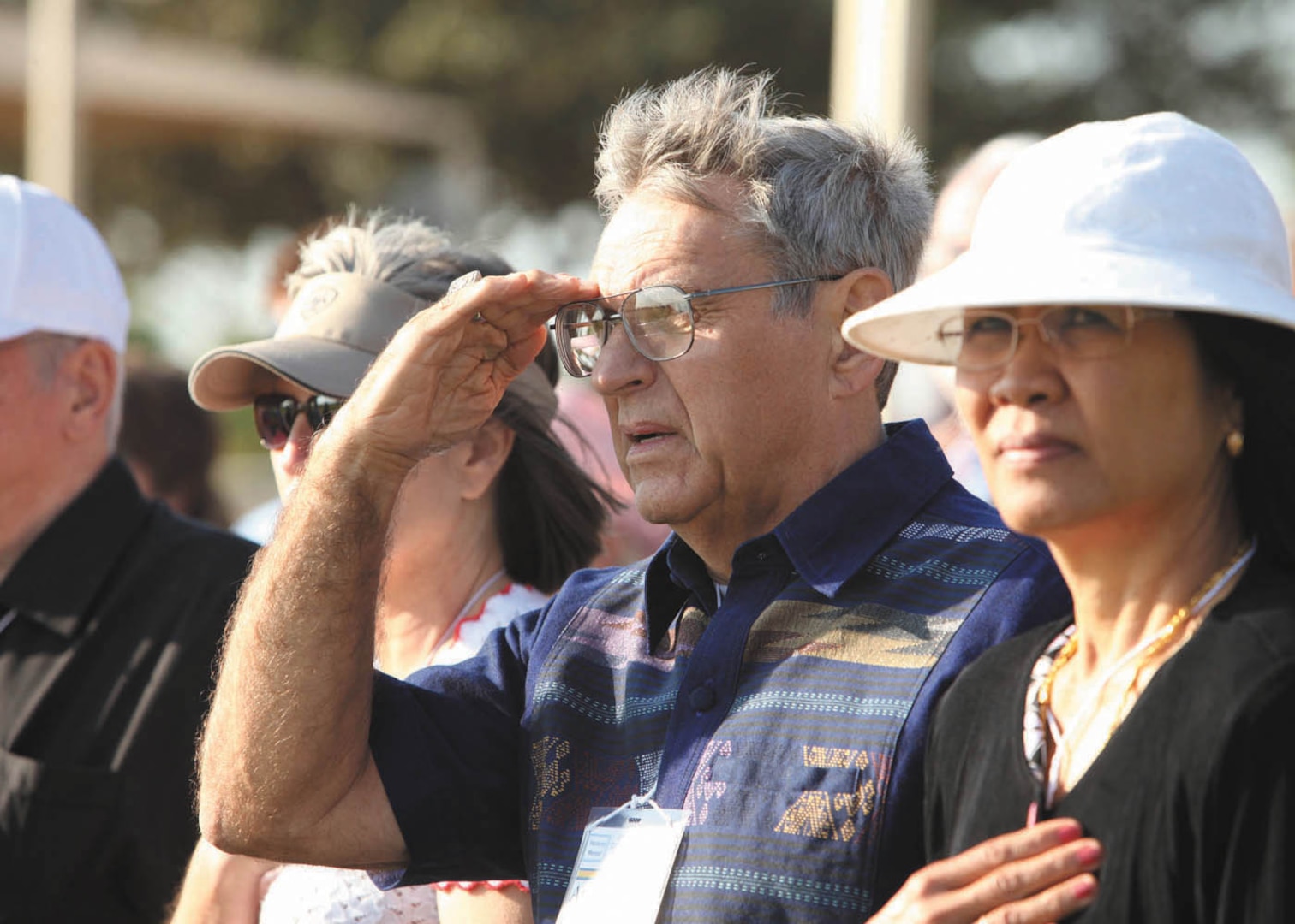 Retired Capt. Art Cormier, a former Vietnam prisoner of war, and his wife, Khamnang, render courtesies during playing of the National Anthem Sept. 23 at the Air Force Basic Military Training graduation. (U.S. Air Force photo/Robbin Cresswell)