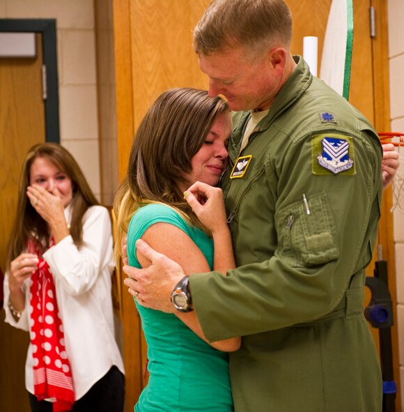 Olivia Ericson, daughter of Lt. Col. Charles Ericson, 116th Air Control Wing, embraces her father for the first time in six months as her mother watches tearfully during a surprise visit to Northside Middle School, Warner Robins, Ga., Sept. 29, 2011.  Lt. Col. Ericson left on a short notice deployment with JSTARS last March.  Returning a day early, the Colonel wanted his daughter to experience a good surprise during the visit to her school. (National Guard photo by Master Sgt. Roger Parsons/Released)
