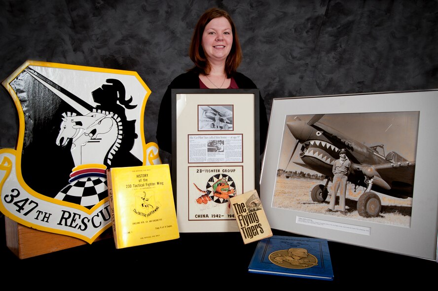 Jennifer Blankinship, 23rd Wing historian, stands alongside several Flying Tiger history artifacts. The wing historian is charged with keeping an up-to-date archive of the wing’s annual history. These archives detail all main events that happen on base and the way leadership handles issues that occur. In a given situation, base leadership can use these archives to look back at Moody’s history to gauge how similar events took place and how they were handled by past leadership. (U.S. Air Force Photo by Staff Sgt. Joshua Garcia/Released) 