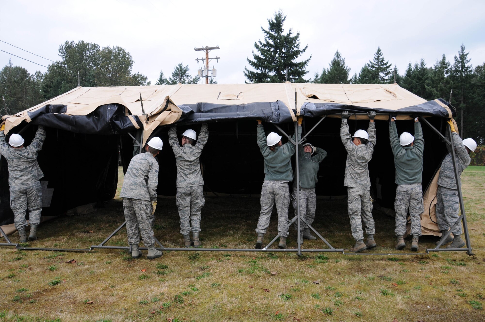 Reservists with the 446th Force Support Squadron Sustainment Services Flight collapse the tent portion of a single paletized expanded kitchen Oct. 2, 2011 at McChord Field during the Unit Training Assembly weekend. It takes up to eight people to set up the tent, and the kitchen must be fully operational within four hours. The SPEK can support the feeding of troops for up to a week in field conditions until a hardened facility is fucntional. Setting up and tearing down the SPEK is an annual training requirement for sustainment services. (U.S. Air Force photo by 2nd Lt. Denise Hauser)