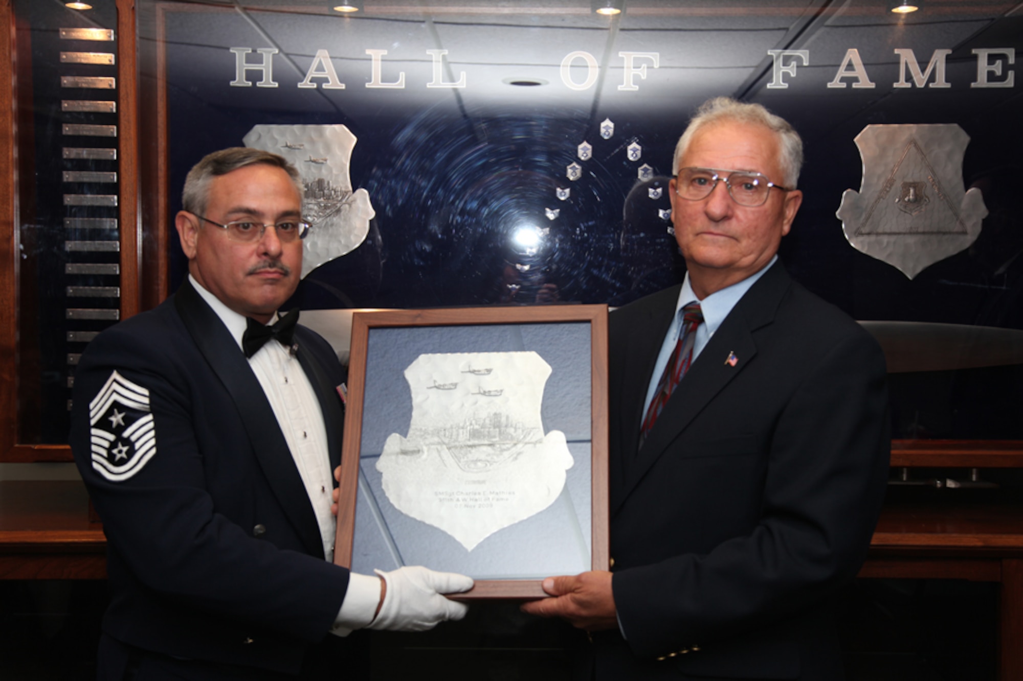 Chief Master Sgt. John Payne, 911th Airlift Wing Command Chief, presents Senior Master Sgt. (retired) Charles E. Mathias with the 911th AW Hall of Fame Shield during his induction ceremony, Oct. 1. Senior Master Sgt. Mathias is the 21st person to be inducted into the 911th AW Hall of Fame since its founding in 1989. (U.S. Air Force photo/ Senior Airman Jonathan G. Hehnly)