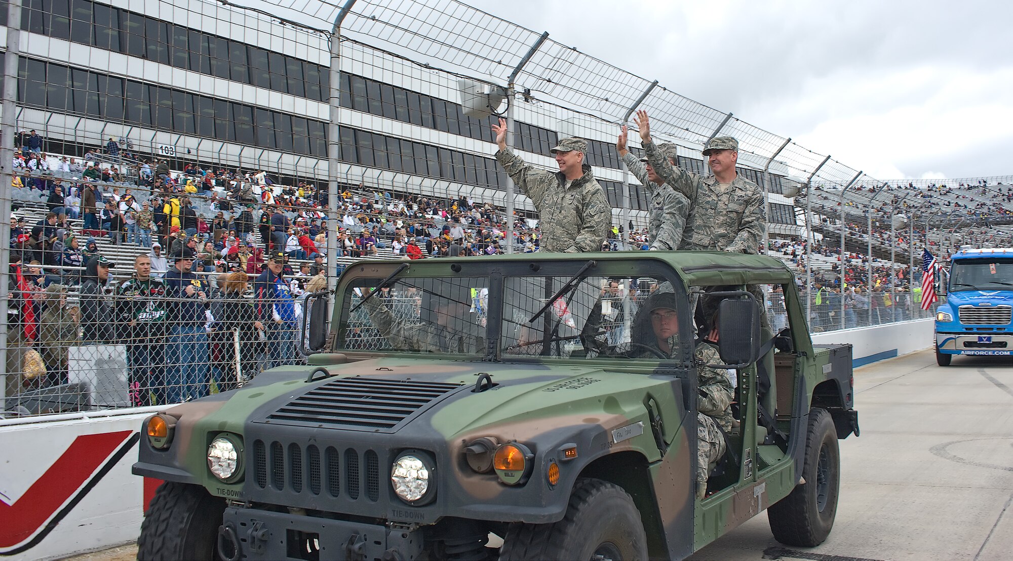 Col. Mark Camerer (left), commander of the 436th Airlift Wing, Col. Randal Bright, commander of the 512th Airlift Wing, and Chief Master Sgt. James Lucas, command chief master sergeant of the 436th, wave to the crowd during the pre-race ceremonies at Dover Downs Oct. 2, 2011. The military had a visible presence at NASCAR. (U.S. Air Force photo by Airman 1st Class Samuel Taylor)  