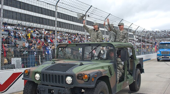 Col. Mark Camerer (left), commander of the 436th Airlift Wing, Col. Randal Bright, commander of the 512th Airlift Wing, and Chief Master Sgt. James Lucas, command chief master sergeant of the 436th, wave to the crowd during the pre-race ceremonies at Dover Downs Oct. 2, 2011. The military had a visible presence at NASCAR. (U.S. Air Force photo by Airman 1st Class Samuel Taylor)  