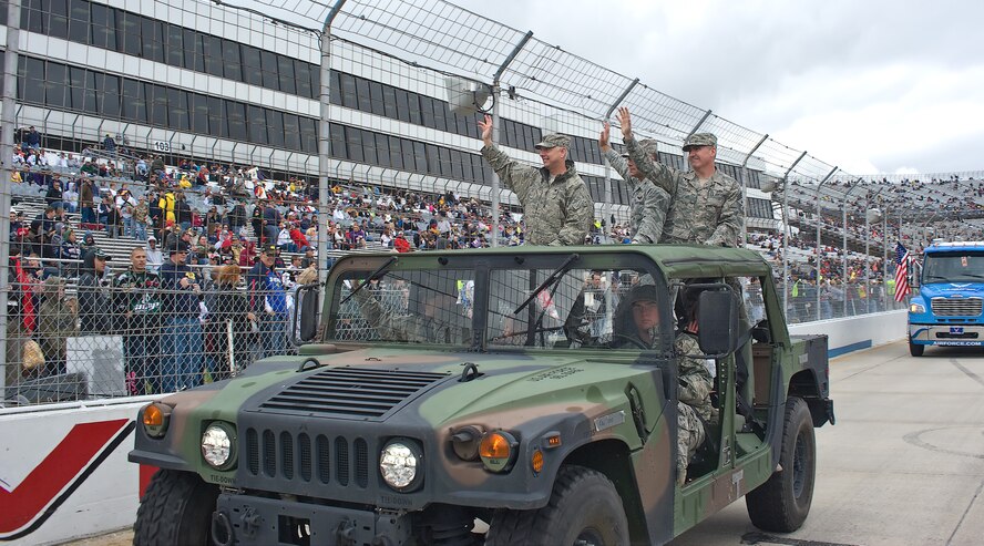 Col. Mark Camerer (left), commander of the 436th Airlift Wing, Col. Randal Bright, commander of the 512th Airlift Wing, and Chief Master Sgt. James Lucas, command chief master sergeant of the 436th, wave to the crowd during the pre-race ceremonies at Dover Downs Oct. 2, 2011. The military had a visible presence at NASCAR. (U.S. Air Force photo by Airman 1st Class Samuel Taylor)  