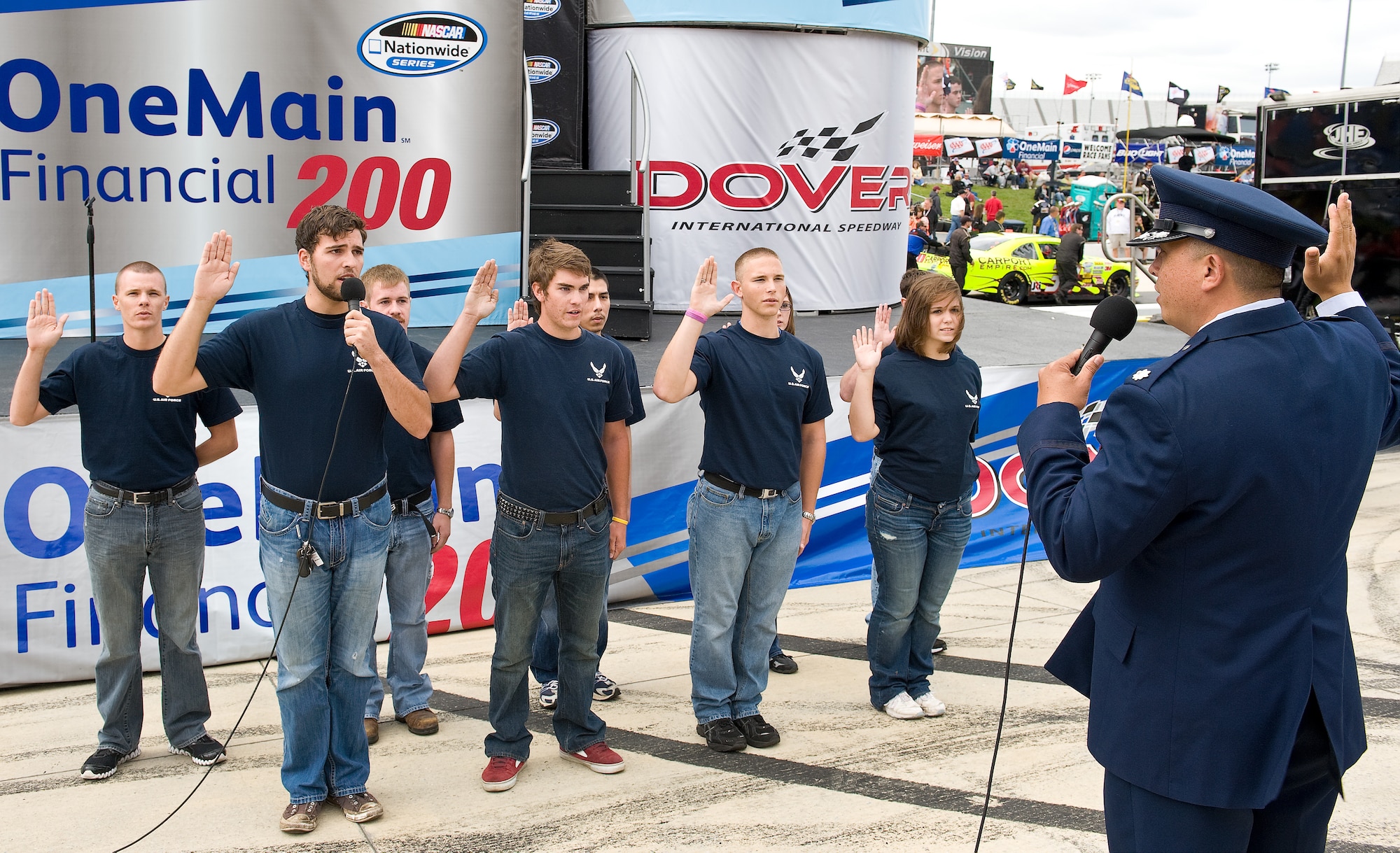Lt. Col. Ricardo Trimillos, commander of the 314th Recruiting Squadron, administers the oath of enlistment to Delayed Entry Program recruits during pre-race festivities Oct. 1, 2011, at the OneMain Financial 200 NASCAR Nationwide Series race at Dover International Speedway in Dover, Del. (U.S. Air Force photo by Roland Balik)