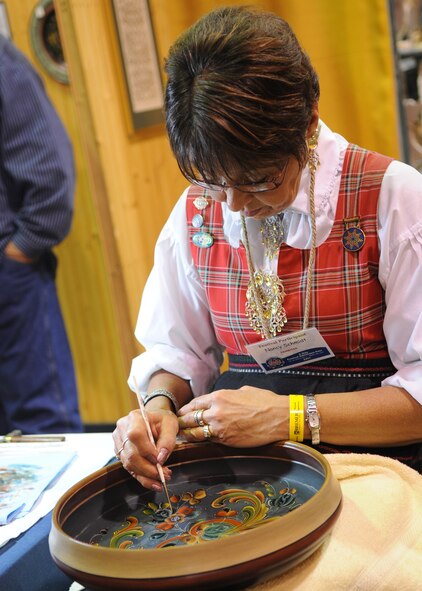 MINOT, N.D. – Nancy Schmidt, Vesterheim National Gold Medalist Rosemaler, demonstrates rosemaling at the Norsk Hostfest here, Sept. 30. Schmidt first became interested in Rosemaling in 1977 and has been improving her talent ever since. The Minot Norsk Hostfest is North America’s largest Scandinavian festival and successfully integrates Minot Airmen and residents together. The festival started Sept. 27 and ended Oct. 1 at the Minot State Fair Grounds. (U.S. Air force photo/Senior Airman Ashley N. Avecilla)