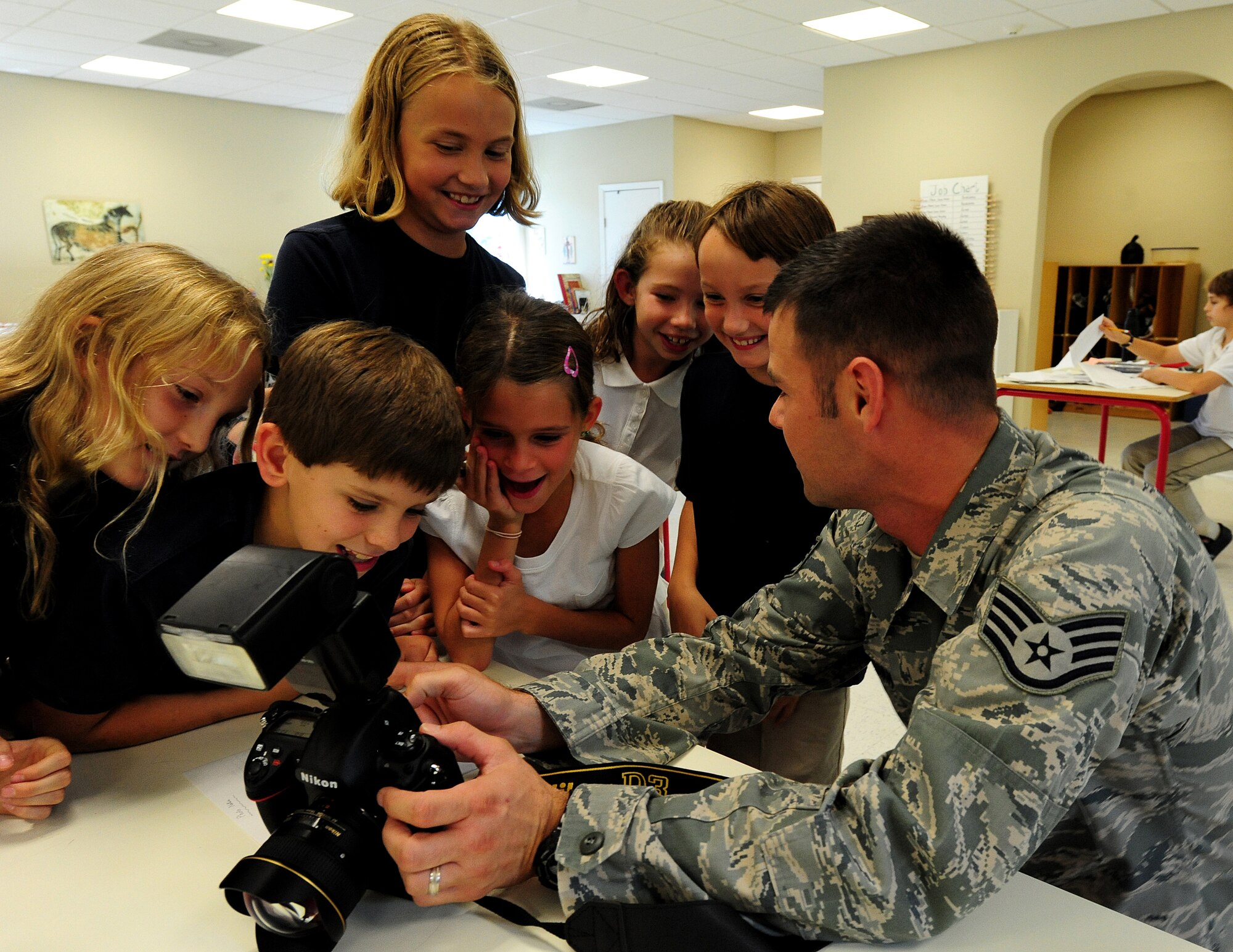 Staff Sgt. Michael Zimmerman shows elementary school students a photo he took Sept. 27 at Charles Towne Montessori School in Charleston. Two photographers from the 1st Combat Camera Squadron volunteered to teach a group of six upper elementary school students basic photography skills.The students will be taking photos for their yearbook. Zimmerman is a photographer at the 1CTCS.  (U.S. Air Force photo/ Staff Sgt. Nicole Mickle)