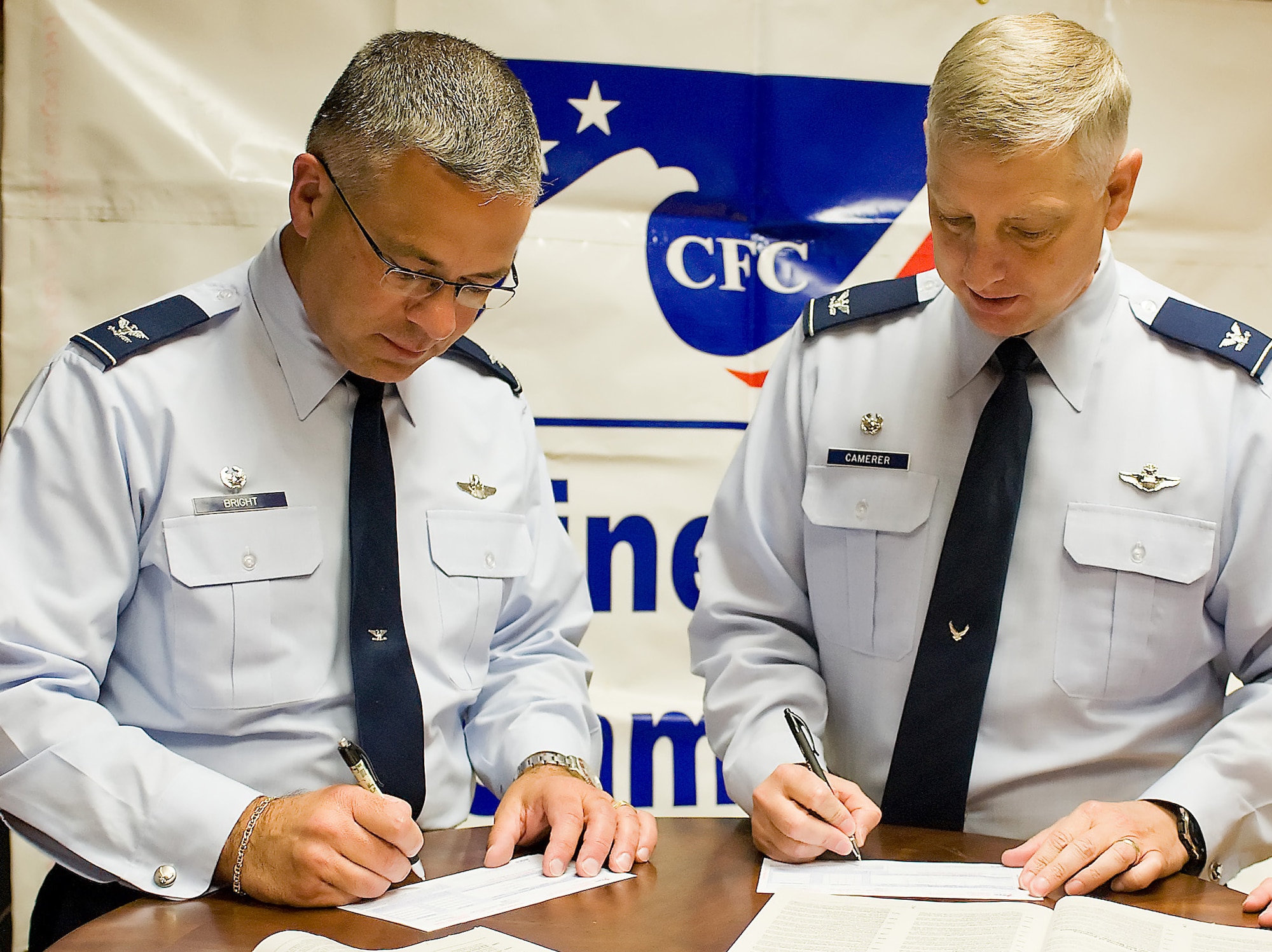 Col. Randal Bright (left), commander of the 512th Airlift Wing, and Col. Mark Camerer, commander of the 436th Airlift Wing, make the first contributions from Dover Air Force Base, Del., to the Combined Federal Campaign Oct. 3, 2011. Dover AFB has set a goal to raise more than $180,000 during the campaign, which last until Nov. 10, 2011. (U.S. Air Force photo by Steve Kotecki)