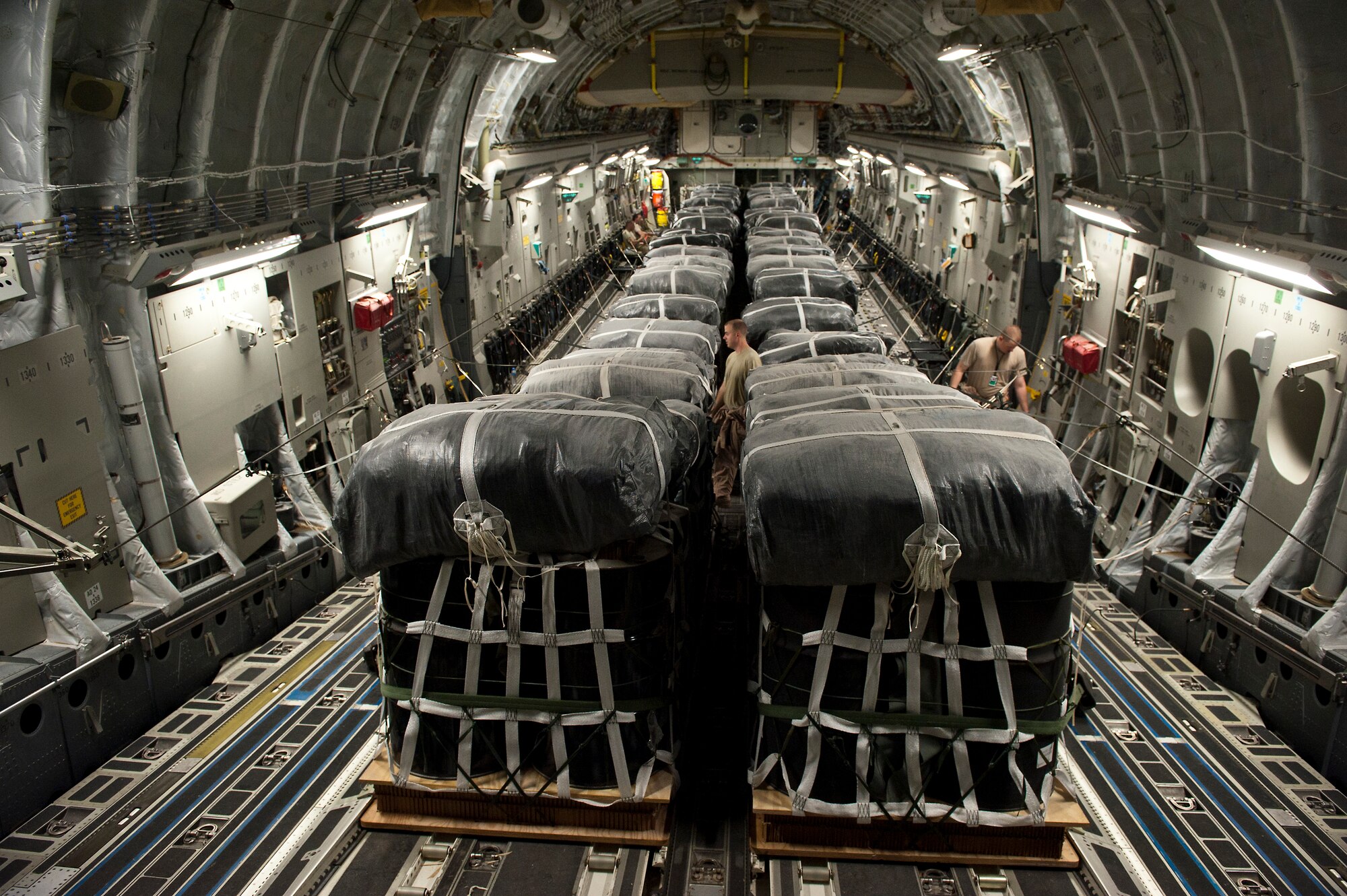 U.S. Air Force Staff Sgt. Peter Jensen (right) and Staff Sgt. Anthony Fuller, loadmasters assigned to the 816th Expeditionary Airlift Squadron, make final safety checks to airdrop bundles in the cargo bay of a C-17 Globemaster III on Sept 30, 2011. Jensen, Fuller and the other crew members of the C-17 air dropped these 40 bundles to a remote outpost in Afghanistan. Aerial delivery of critical supplies decreases the total number of resupply convoys conducted in high threat areas.  (U.S. Air Force Photo/Master Sgt. Jeffrey Allen)