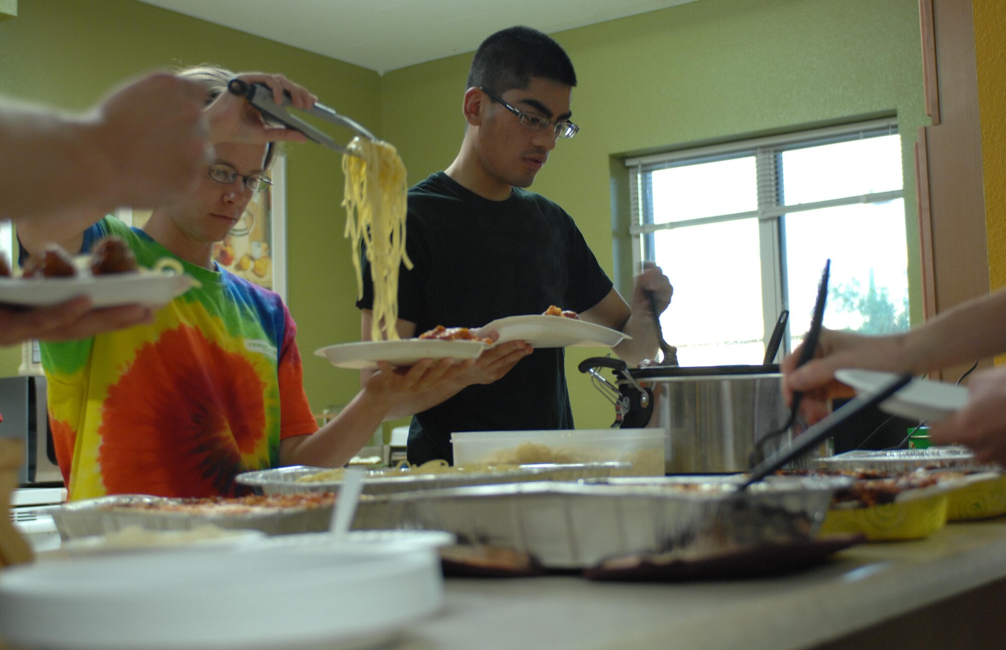 DAVIS-MONTHAN AIR FORCE BASE, Ariz. -- Airmen prepare plates of Italian cuisine, provided for them by the D-M Chiefs Group, at the Loft here Oct. 2. Every Sunday the Loft hosts a dinner for Airmen living in the dorms; once a month they allow a base organization to host the dinner. This month the D-M Chiefs Group provided the Sunday meal. (U.S. Air Force photo/Airman 1st Class Saphfire D. Cook)