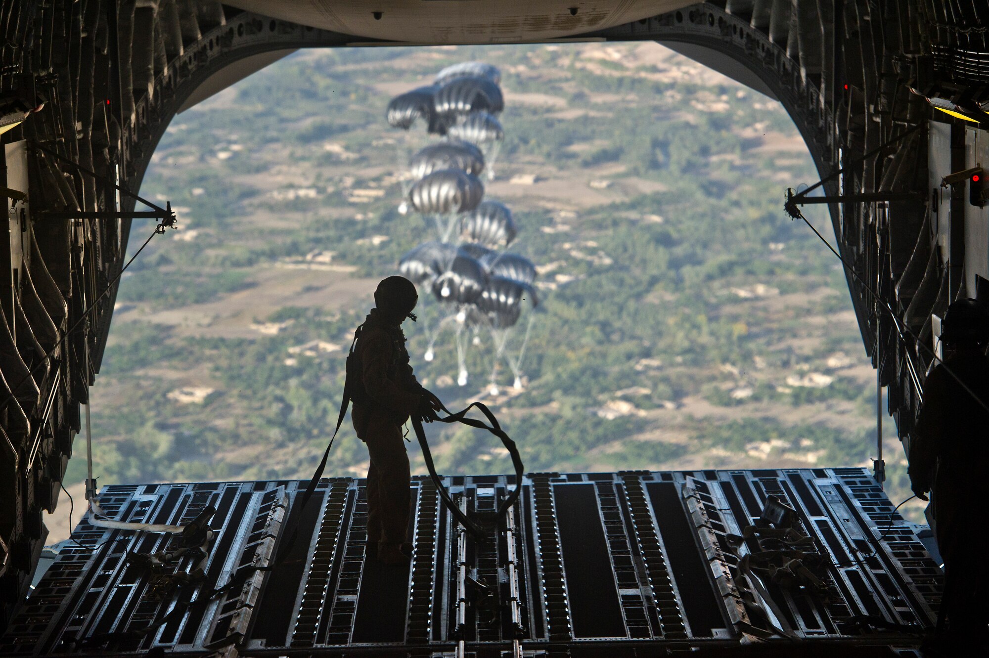 U.S. Air Force Staff Sgt. Peter Jensen, a loadmaster assigned to the 816th Expeditionary Airlift Squadron, collects straps that restrained airdrop bundles in the back of a C-17 Globemaster III on Sept 30, 2011. Jensen and the crew of the C-17 air dropped 40 bundles to a remote outpost in Afghanistan. Aerial delivery of critical supplies decreases the total number of resupply convoys conducted in high threat areas.  (U.S. Air Force Photo/Master Sgt. Jeffrey Allen)