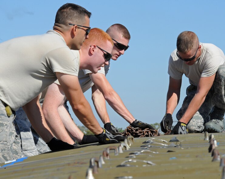 Airmen from the 2nd Munitions Squadron run chains across 500-pound bombs during the Global Strike Challenge Munitions Maintenance Competition on Barksdale Air Force Base, La., Oct. 3. The chains are used to prevent the bombs from sliding or falling off a trailer. (U.S. Air Force photo/Airman 1st Class Micaiah Anthony)(RELEASED)
