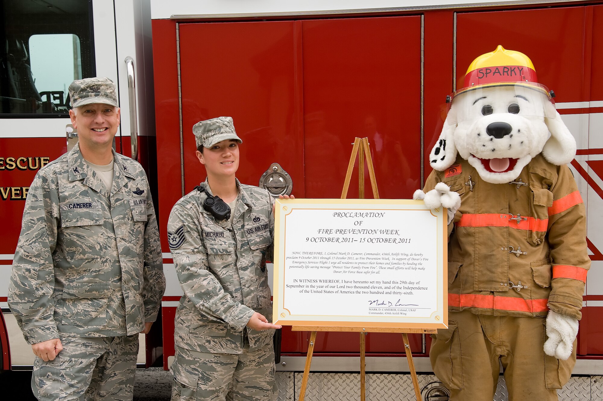 Col. Mark Camerer (left), commander of the 436th Airlift Wing, Tech. Sgt. Heather Michaud, NCO in charge of fire prevention with the 436th Civil Engineer Squadron, and Sparky stand with the Proclamation of Fire Prevention Week Sept. 27, 2011, at Dover Air Force Base, Del. Fire Prevention Week kicks off Oct. 9 and ends Oct. 15. (U.S. Air Force photo by Adrian Rowan) 