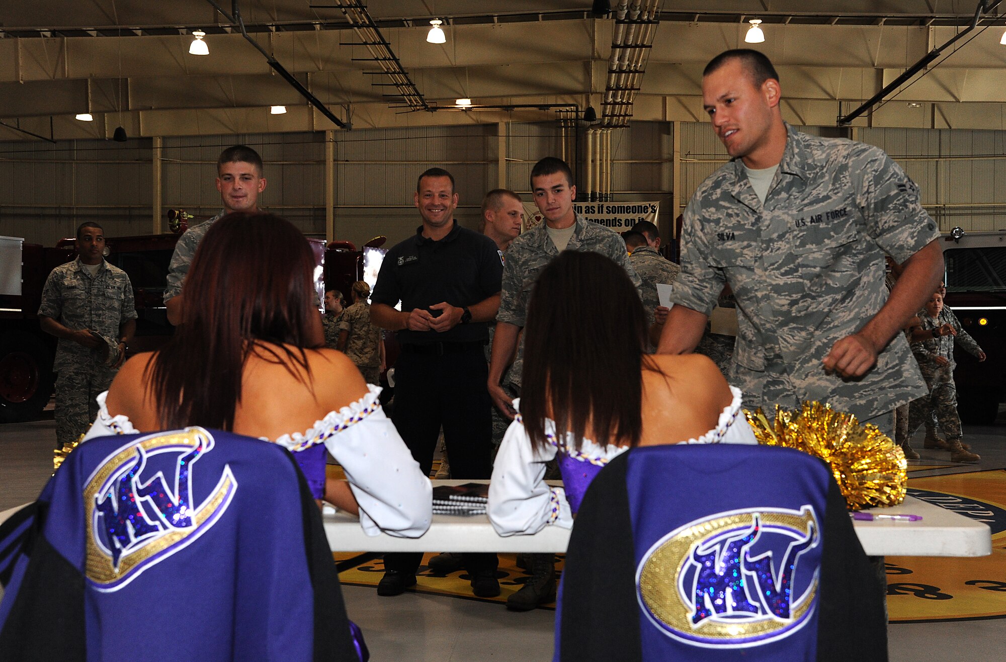 GOODFELLOW AIR FORCE BASE, Texas -- Two Minnesota Vikings cheerleaders sign autographs for 312th Training Squadron instructors and student inside the Louis F. Garland Fire Academy High Bay here Sept 30. The cheerleaders visited Goodfellow to boost morale. (U.S. Air Force photo/Airman 1st Class Michael Smith)   