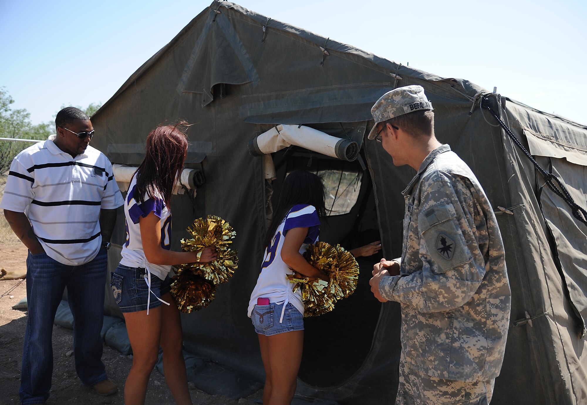 GOODFELLOW AIR FORCE BASE, Texas -- Army Staff Sgt. Thomas Berquam, 344th Military Intelligence Battalion Instructor, shows two Minnesota Vikings cheerleaders around Camp Sentinel Sept. 30. The two cheerleaders visited Goodfellow to boost morale. (U.S. Air Force photo/Airman 1st Class Michael Smith)   