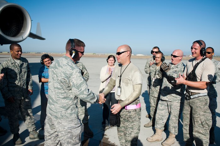 Capt. Christopher Jacobson, 728th Air Mobility Squadron Aerial Port Flight commander, congratulates Staff Sgt. Nathan Dunn, a deployed aerial port expeditor, for being the first APEX Airman to reach 1,000 loads Oct. 3, 2011, at Incirlik Air Base, Turkey. The APEX program allows cargo to be loaded onto aircraft without a loadmaster. (U.S. Air Force photo by Senior Airman Clayton Lenhardt/Released)