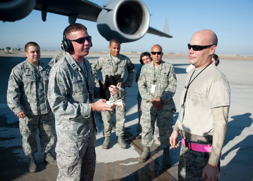 Staff Sgt. Nathan Dunn, 728th Air Mobility Squadron, is awarded a bone to celebrate his 1,000th load as an aerial port expeditor Oct. 3, 2011, at Incirlik Air Base, Turkey. Dunn is the first APEX Airman to reach this milestone. Air transportation Airmen are nicknamed "Port Dawgs," and aerial ports use the bone to recognize Airmen who show dedication and passion to air transportation. (U.S. Air Force photo by Senior Airman Clayton Lenhardt/Released)