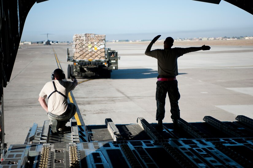 Staff Sgt. Nathan Dunn, right, 728th Air Mobility Squadron, guides cargo into a C-17 Globemaster III Oct. 3, 2011, at Incirlik Air Base, Turkey. Dunn is the first aerial port expeditor to reach 1,000 cargo loads. The APEX program allows cargo to be loaded and unloaded onto aircraft without a loadmaster. (U.S. Air Force photo by Senior Airman Clayton Lenhardt/Released)