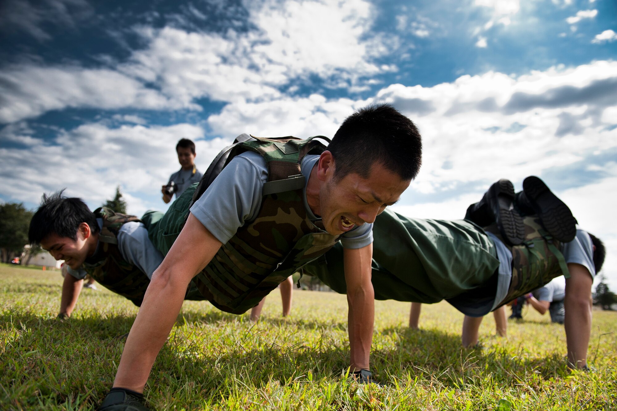 YOKOTA AIR BASE, Japan -- A team of Airmen from the Japan Air Self-Defense Force performs ranger push-ups during the Combat Endurance Challenge at Yokota Air Base, Japan, Oct. 1, 2011. The JASDF team was one of the few teams able to complete all 30 ranger pushups, a task requiring each member to put their feet on each other's back using only their arms to support the team's combined weight. (U.S. Air Force photo/Staff Sgt. Samuel Morse)