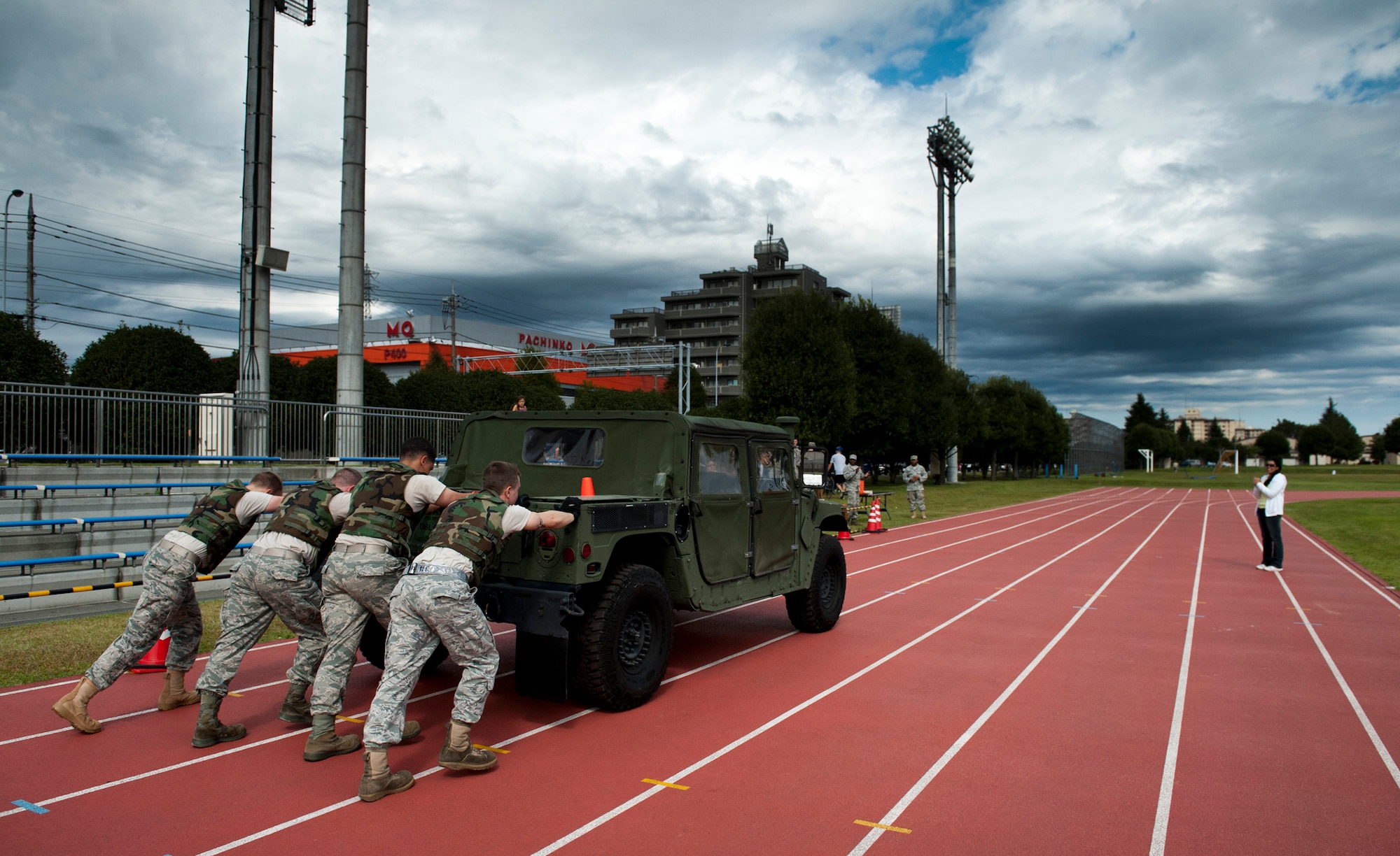 YOKOTA AIR BASE, Japan -- A team of Airmen from the 374th Maintenance Squadron accessories flight push a humvee as their first task during the Combat Endurance Challenge at Yokota Air Base, Japan, Oct. 1, 2011. The humvee was steered by a team member, but the engine was turned off. (U.S. Air Force photo/Staff Sgt. Samuel Morse)
