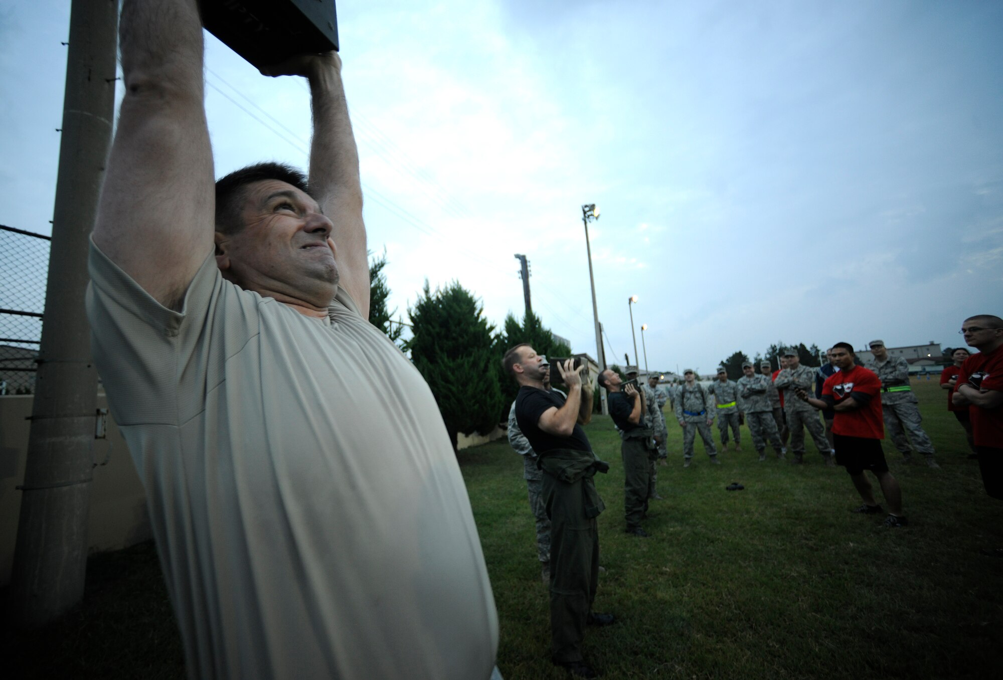 Chief Master Sgt. Scott Delveau, 8th Fighter Wing command chief, lifts a 30-pound ammunition case during the Marine Corps Combat Fitness Test at Kunsan Air Base, Republic of Korea, Sept. 30, 3011. The test consisted of movement to contact; 880 yard run, 30 pound ammunition lift and the maneuver under fire, which was a 300 yard shuttle run that includes a variety of combat-related tasks, to include: crawls, buddy drags and carries, ammunition resupply, grenade throw and agility running. (U.S. Air Force photo by Staff Sgt. Rasheen A. Douglas/Released)