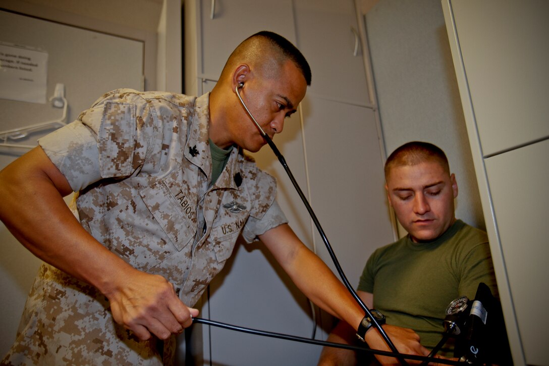 Petty Officer 2nd Class Wendell Tabios, hospital corpsman, 15th Marine Expeditionary Unit Command Element, checks vital signs on Sgt. Fernando Fuentes, a supply clerk with the unit, at the command post, October 5. There are no medical personnel organic to the Marine Corps. For these needs, Marines rely on the Navy’s corpsmen, more commonly referred to as “docs.” As a team they are in charge of meeting the medical needs of 15th MEU personnel. (U.S. Marine Corps photo by Cpl. John Robbart III)
