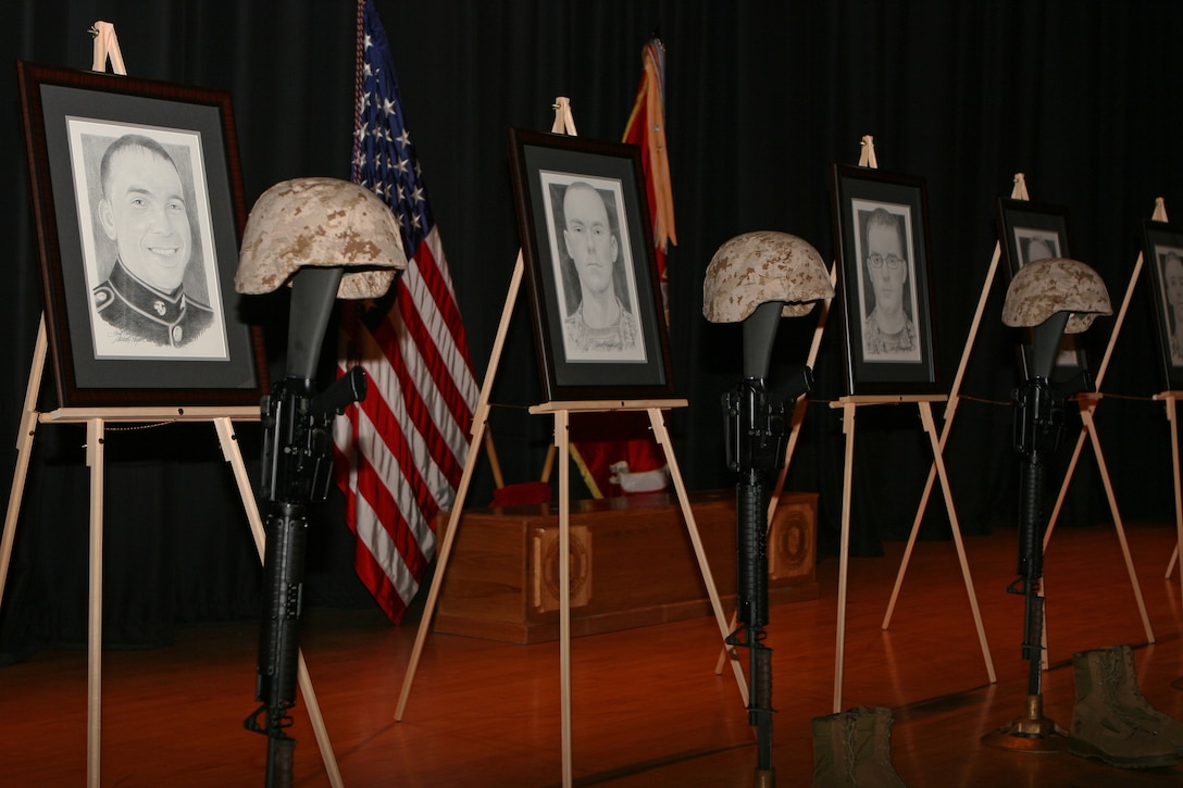 The traditional battlefield memorial cross, a statue of a rifle, combat boots and identification tags, symbolizing the sacrifice made by fallen Marines, stands on display during a memorial service for fallen members of 3rd Battalion, 2nd Marine Regiment, 2nd Marine Division, Oct. 5, aboard Marine Corps Base Camp Lejeune. Next to each of the statues stood a portrait by which their fellow Marines could remember the faces of the men who gave the ultimate sacrifice.