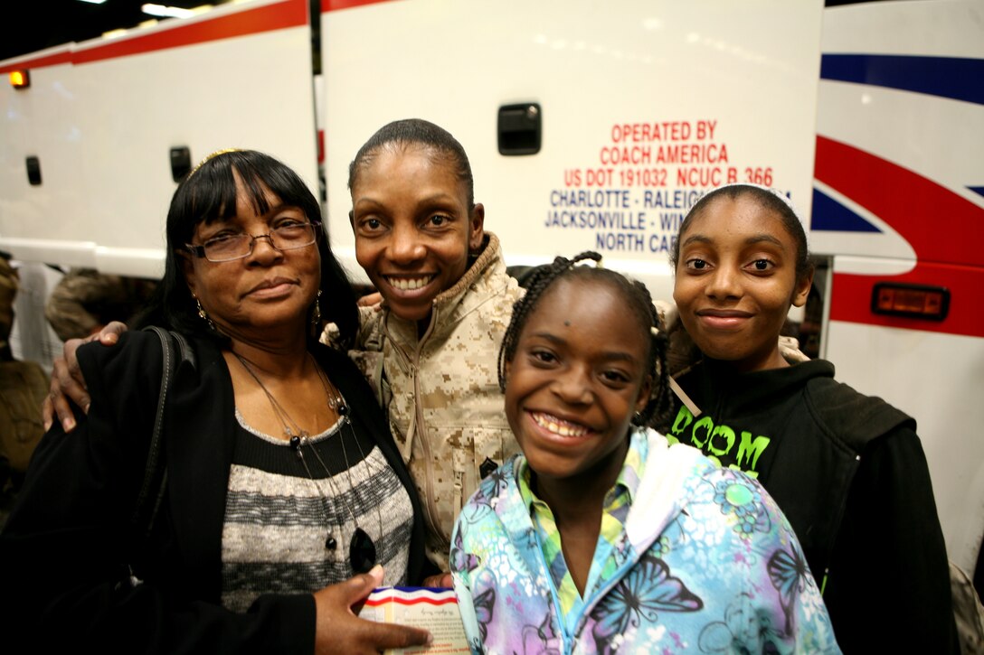 Gunnery Sgt. Tracey D. Nicholson (middle), from Newport News, Va., a career retention specialist with 2nd Maintenance Battalion, Combat Logistics Regiment 25, 2nd Marine Logistics Group, reunites with her family during a homecoming Oct. 5, 2011, aboard Camp Lejeune, N.C. The troops returned home from a seven-month deployment to Afghanistan in support of International Security Assistance Force operations. (Photo by Cpl. Bruno J. Bego)