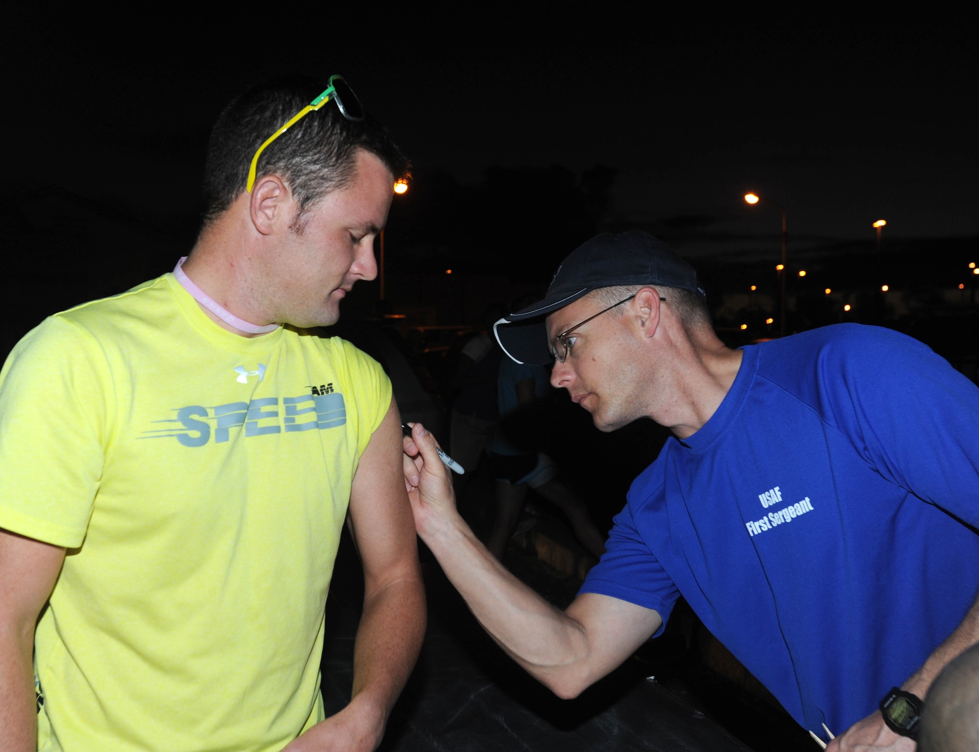 Airman 1st Class Nathan Johnson, 18th Communications Squadron airfield systems technician, receives a registration number from Master Sgt. Thomas Jones, 18th Aircraft Maintenance Squadron first sergeant, for a challenge run fundraiser beginning at the Risner Fitness Center Sept. 30. The 6-, 10- and 20-kilometer runs were hosted by the Kadena first sergeants to support their non-profit program, Operation Warm Heart. More than 300 people registered to participate in the event. (U.S. Air Force photo/Tech. Sgt. Amanda Savannah)