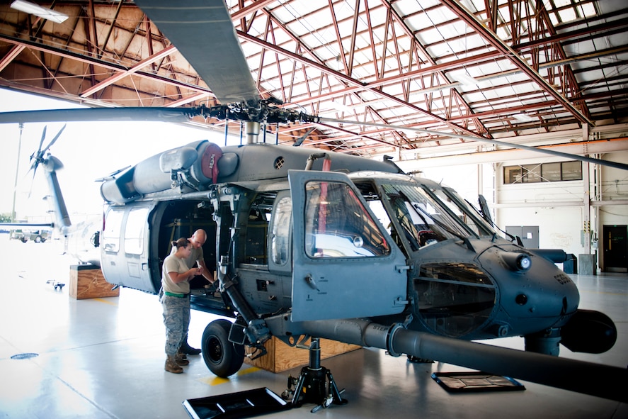 U.S. Air Force Airman 1st Class Joshua Jaynes, 41st Helicopter Maintenance Unit crew chief apprentice, and Senior Airman Sindy Keefe, 41st HMU engine troop, discuss maintenance while working on an HH-60G Pave Hawk Oct. 5, 2011, at Moody Air Force Base, Ga. The Airmen helped conduct repairs to a small crack on the helicopter that could potentially create greater damage to the aircraft if gone untreated. (U.S. Air Force photo by Staff Sgt. Jamal D. Sutter/Released)