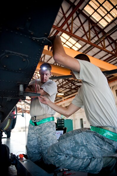 U.S. Air Force Staff Sgt. Michael Lindemann, left, and Senior Airman Keith Cassell, 41st Helicopter Maintenance Unit electronic warfare systems craftsman and journeyman, work on repairs to an HH-60G Pave Hawk wire harness Oct. 5, 2011, at Moody Air Force Base, Ga. Lindemann has been in his career field for eight years and has been at Moody since April 2010. Cassell has been to Moody for a week and comes from Dyess Air Force Base, Texas, where he worked on B-1B Lancers. (U.S. Air Force photo by Staff Sgt. Jamal D. Sutter/Released) 