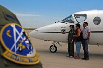 LAUGHLIN AIR FORCE BASE, Texas -- Maria Ramon, an honorary pilot for a day, and here parents get their picture taken in front of T-1A Jayhawk here Sept. 28. Maria is mentally challenged and was selected to receive an all access tour of Laughlin and had the opportunity to be a pilot for a day. (U.S. Air Force photo/Senior Airman Scott Saldukas)