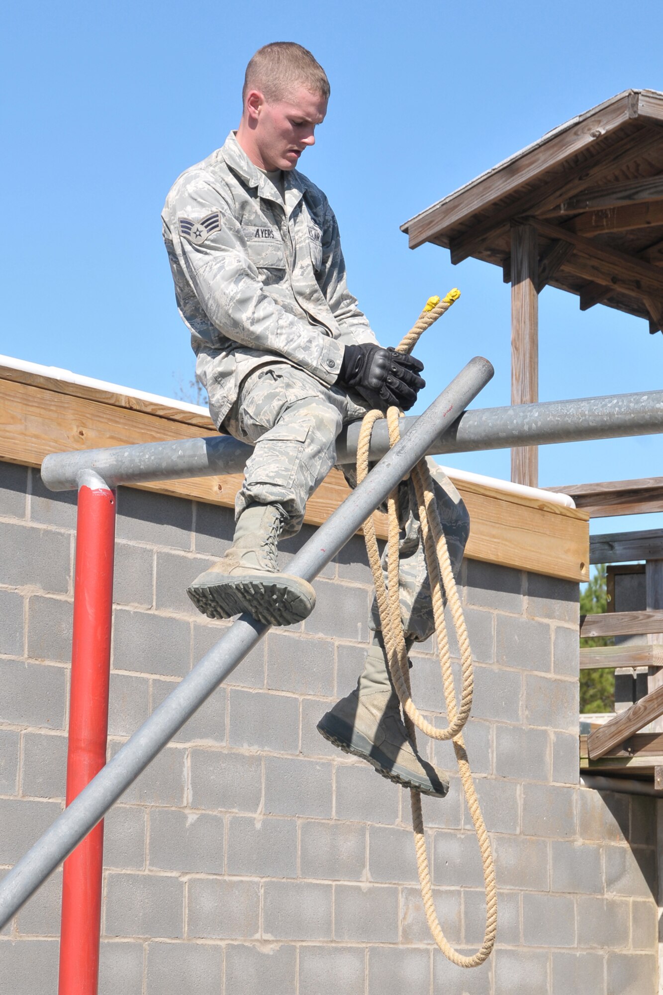 FORT MCCLELLAN, Ala. -- Air Force Reserve Senior Airman Adam Ayers secures a ' pole bridge ' over an obstacle at the Leadership Reaction Course here, October 3, 2011. SRA Ayers is a Security Forces Specialist with the 910th Security Forces Squadron, based at Youngstown Air Reserve Station, OH. Airman Ayers along with other members of the 910th SFS were at Fort McClellan for a four day training exercise designed to sharpen team work skills, test physical fitness and their abilities with small arms as well as ' heavy weapons'. U.S. Air Force photo by Tech. Sgt. James Brock