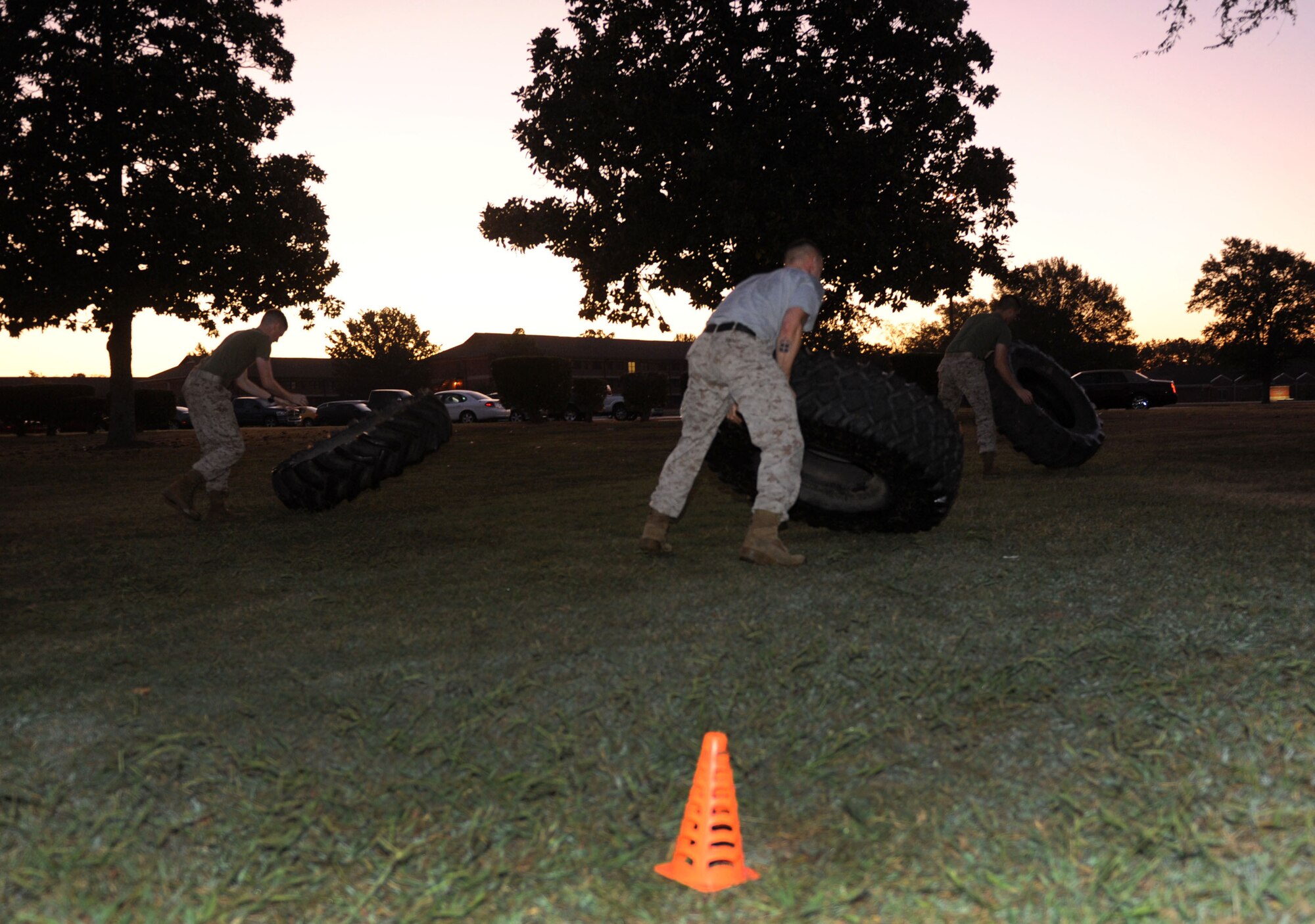 Marine Corps Sgt. Roy Knapp, a Center for Naval Aviation Technician Training detachment avionics instructor, performs a tire flip with students during a combat fitness training exercise, Oct. 5, 2011, at Little Rock Air Force Base, Ark. Combat fitness training is a circuit of two-minute drills that prepare Marines for combat conditioning and readiness. (U.S. Air Force photo by Senior Airman Caleb Pierce) 