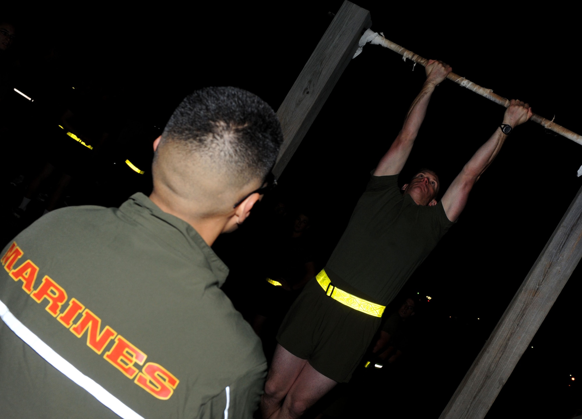 Marine Corps Staff Sgt. Sergio Molina, a Center for Naval Aviation Technician Training detachment crew chief instructor, observes a student during physical training exercises Oct. 5, 2011, at Little Rock Air Force Base, Ark. Pull-ups are one of three exercises that Marines are tested on for physical fitness. The other components are a three-mile run and crunches. (U.S. Air Force photo by Senior Airman Caleb Pierce)