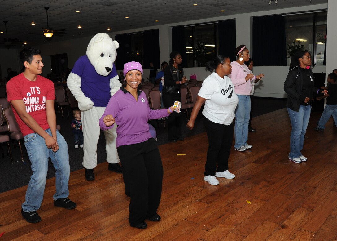 Volunteers at the Pumpkin Bash along with Pablo the Polar Bear, Laugh out Loud Station Waldorf, Md. Mascot, dance ‘the wobble’ during the Pumpkin Bash at the Community Activity Center on Oct. 1. The Pumpkin Bash was a Family Advocacy hosted event which kicked-off Domestic Violence Awareness Month. (U.S. Air Force photo/Airman 1st Class Bahja J. Jones) 

