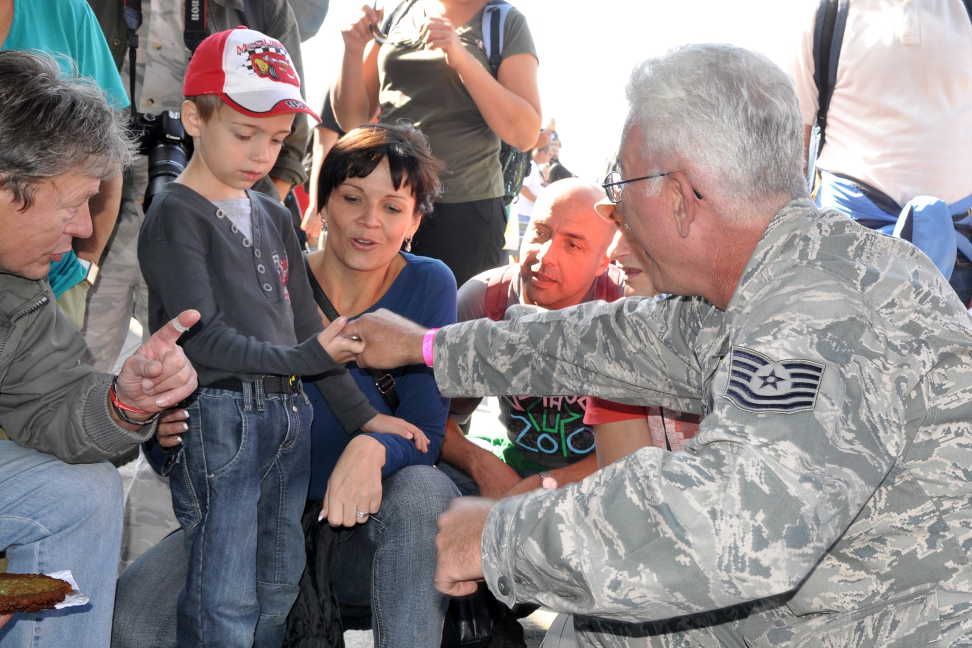 U.S. Air Force Tech. Sgt. David Cates, 307th Aircraft Maintenance Squadron crew chief, gives a 93rd Bomb Squadron coin to a boy during the 11th Annual NATO Days in Ostrava air show, Ostrava, Czech Republic, Sept. 24, 2011. Approximately 225,000 people attended the air show, which is the largest air, military and security show in Central Europe. (U.S. Air Force photo by Tech. Sgt. Jeff Walston/Released)