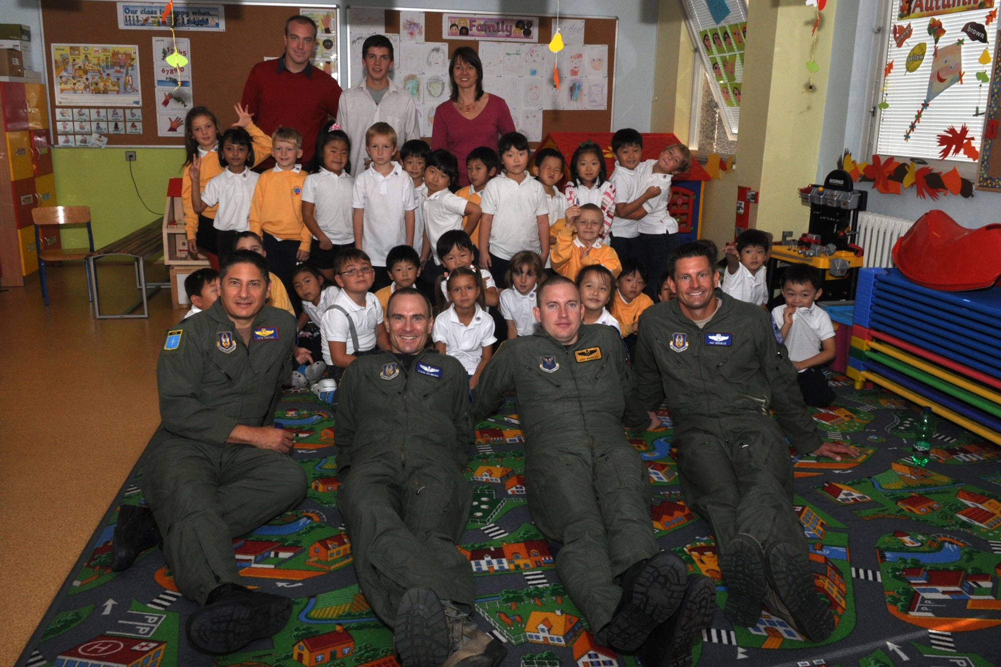 U.S. Air Force Airmen Lt. Col. Pete Costas, 93rd Bomb Squadron pilot, Maj. Stephen Dujmovic, 93rd BS pilot, Capt. Eric Barkley, 11th Bomb Squadron instructor radar navigator and Maj. Pat Booker, 93rd BS instructor pilot, pose for a picture with a group of five and six year old children in year 1 & 2 at the 1st International School of Ostrava in the Czech Republic, Sept. 23, 2011. The 1st ISO is a private, coeducational school, and the Airmen were in the Czech Republic supporting the 11th Annual NATO Days in Ostrava air show, which is the largest air, military and security show in Central Europe. (U.S. Air Force photo by Tech. Sgt. Jeff Walston/Released)