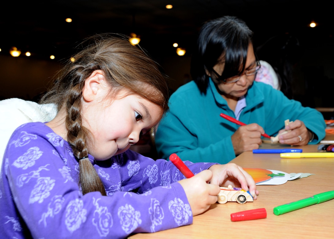 Zoe Lingad, 6, daughter of Tech. Sgt. Mari Lingad, 779th Dental Squadron dental technician, colors a model car with her grandmother, Daisy Peralta during the Pumpkin Bash at the Community Activity Center on Oct. 1. The Pumpkin Bash was a Family Advocacy hosted event which kicked-off Domestic Violence Awareness Month. (U.S. Air Force photo/Airman 1st Class Bahja J. Jones) 