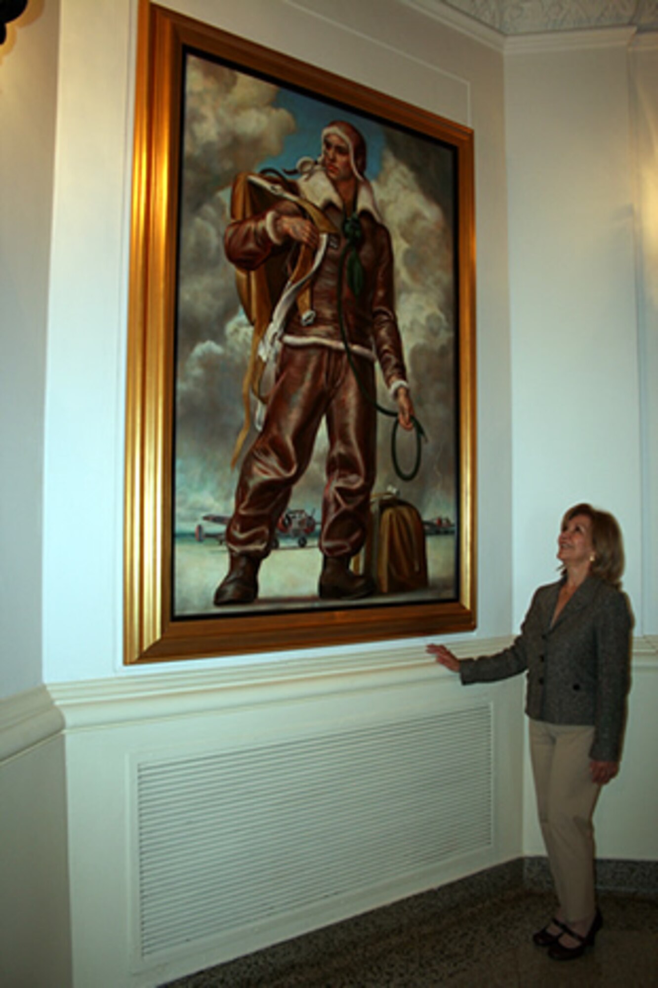 Mary Young, Air Force Personnel Center Civilian Affirmative Employment Program manager, admires a life-sized portrait of a pilot inside the 12th Flying Training Wing headquarters, nicknamed the "Taj Mahal," at Randolph Air Force Base, Texas. Young has served 50 years in Air Force civil service, helping the employment and advancement of women, minorities and those with disabilities. (U.S. Air Force photo/Debbie Gildea) 
