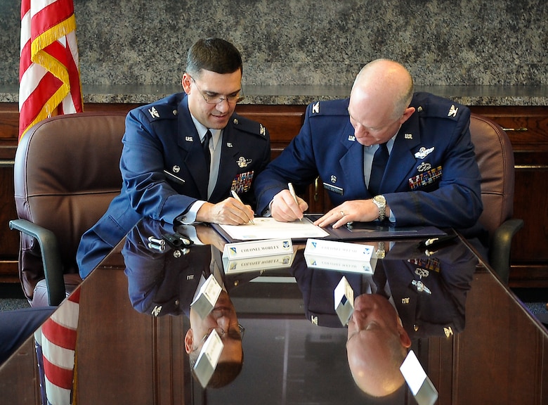 U.S. Air Force Col. L. Dean Worley Jr., left, 461st Air Control Wing commander, and Col. William Welsh, 116th Air Control Wing commander, sign a memorandum of understanding prior to the 116th ACW Change of Command and the 461st ACW activation ceremonies at the Museum of Aviation, Robins Air Force Base, Ga., Sept. 30, 2011.  The memorandum of understanding established the initiative to optimize day-to-day operations of both wings working together as an active associate unit.  (National Guard photo by Master Sgt. Roger Parsons/Released)