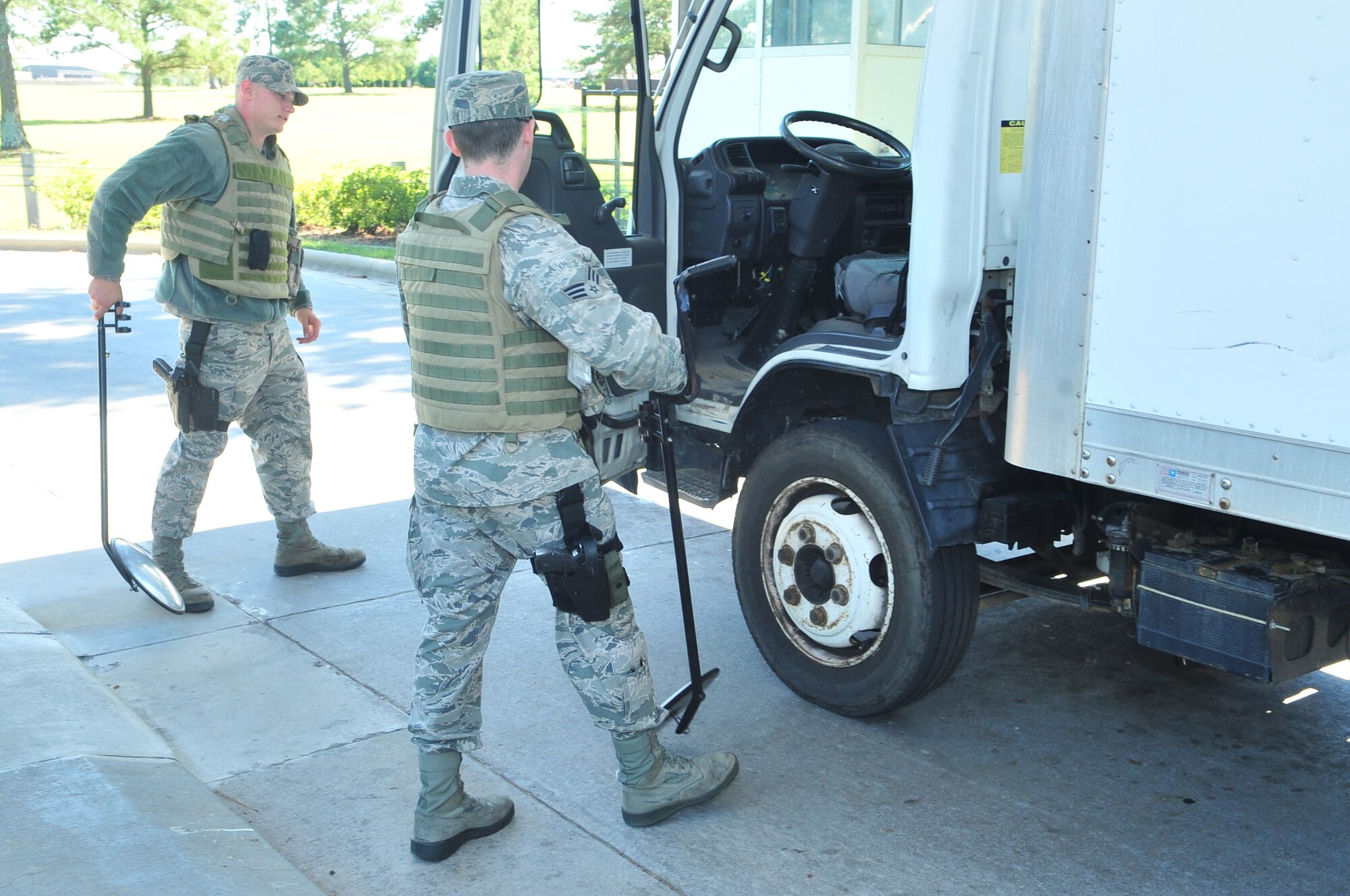 Airman 1st Class Derek Henderson and Senior Airman Jonathan Madden prepare to inspect a cargo truck entering Seymour Johnson Air Force, Base, N.C., Oct. 4, 2011. Henderson and Madden are security forces augmentees who are completing an additional duty outside of their normal duties to assist the 4th Security Forces Squadron in securing the base perimeter. Henderson is from Waitsburg, Wash., and is a 4th Logistics Readiness Squadron vehicle mechanic and Madden is a 4th Medical Operations Squadron mental health technician and hails from Hampden, Mass. (U.S. Air Force photo by Senior Airman Marissa Tucker) 