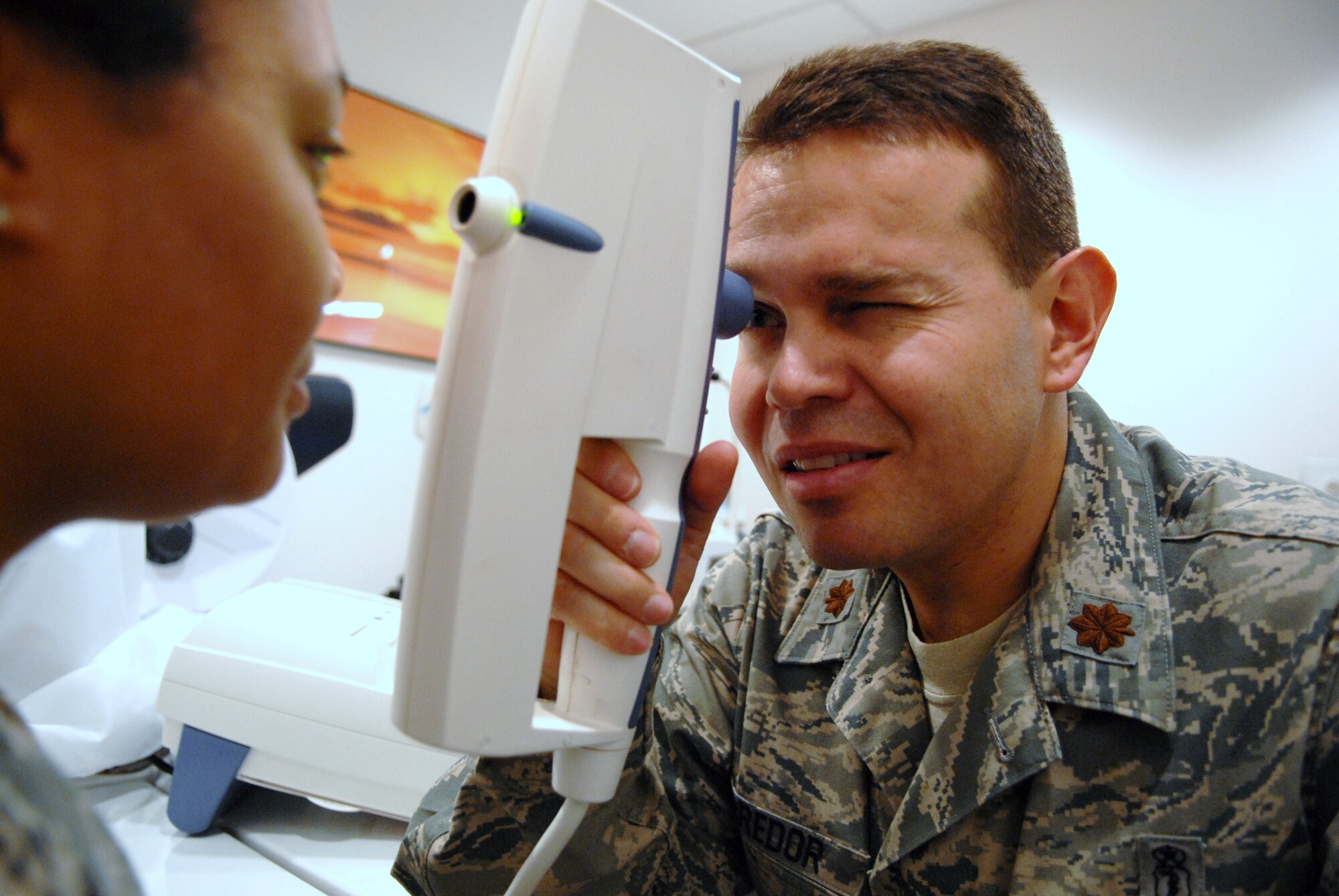 Maj. (Dr.) Oscar Corredor examines a patient at the Main Clinic. Dr. Corredor arrived as an optometrist with the 95th Medical Group after beginning his higher education journey with the Community College of the Air Force. (Air Force photo by Senior Airman William O'Brien)