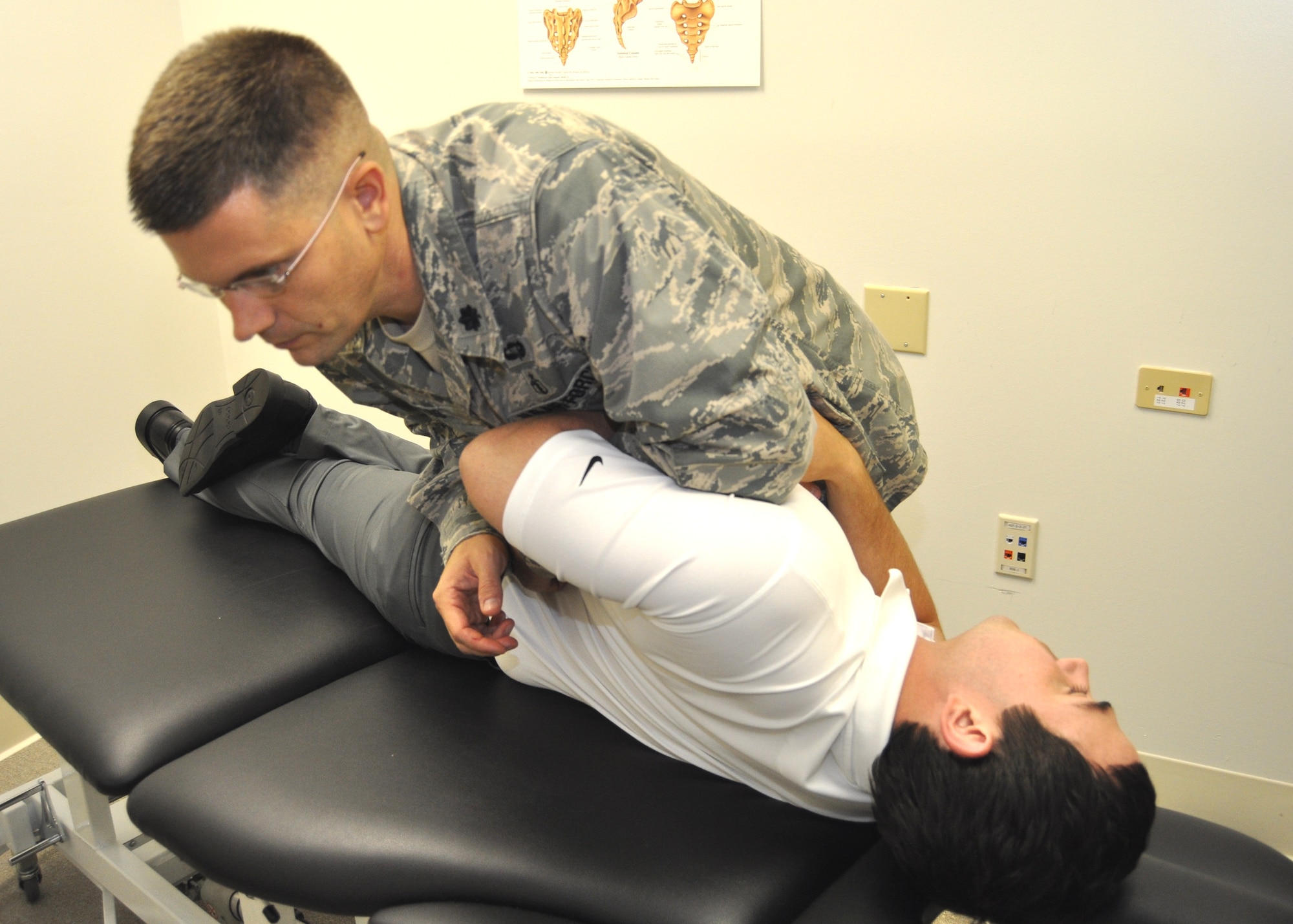 Lt. Col. John Childs, 81st Surgical Operations Squadron, demonstrates spinal manipulation for acute lower back pain on simulated patient Kevin Wait, a physical therapy clinic staff physical therapist.  (U.S. Air Force photo by Steve Pivnick)